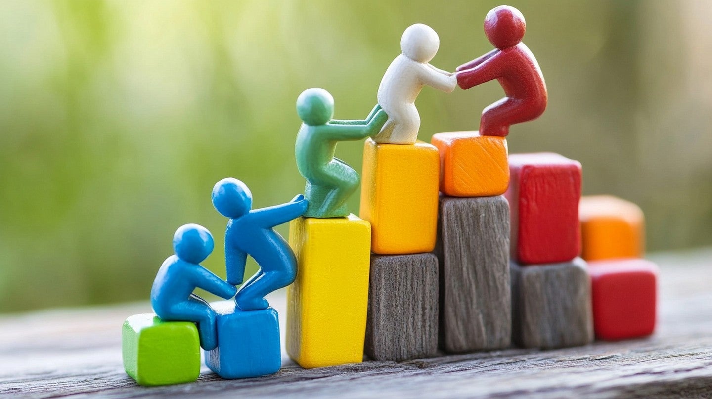 A image of figures helping each other up a hill